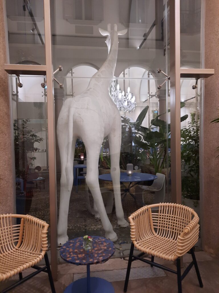 a statue of a giraffe in a glass room