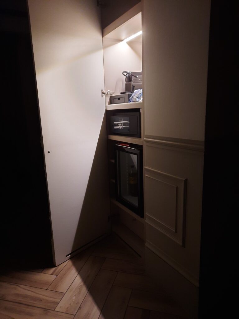 a small closet with a small door and a small refrigerator