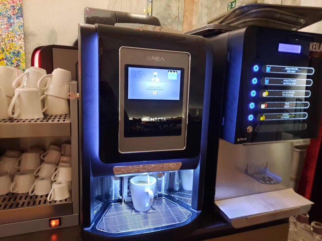 a coffee machine with a screen and a cup