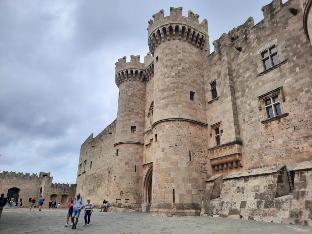 a stone castle with people walking in front of it