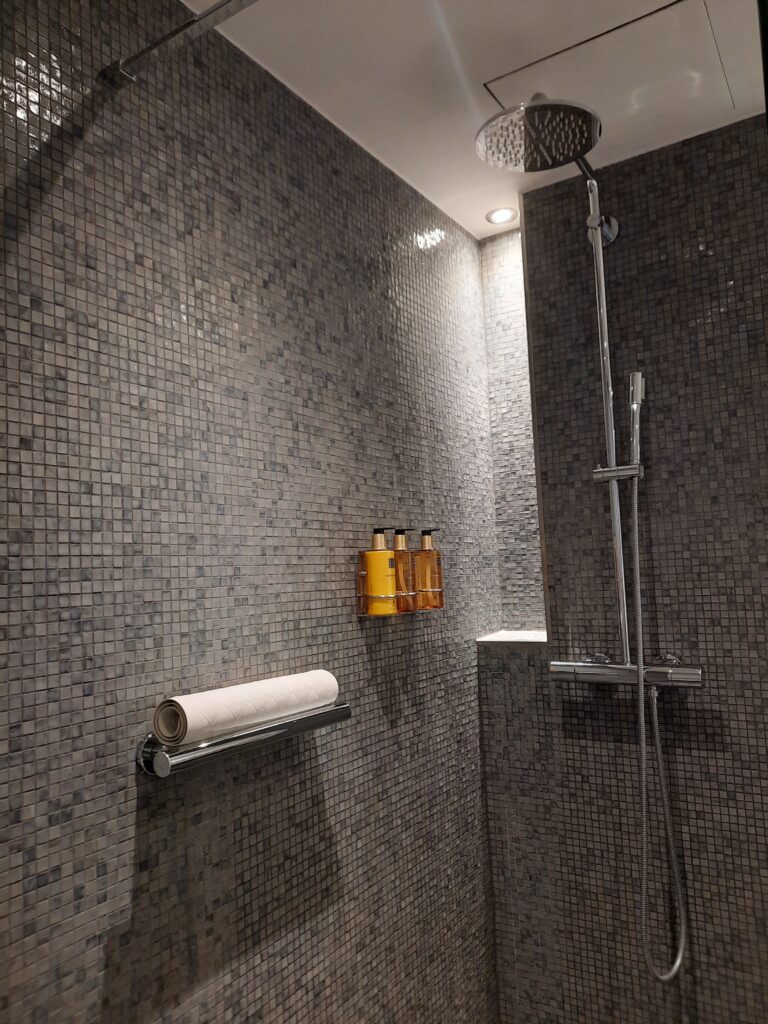 a shower with a roll of toilet paper and a roll of toilet paper