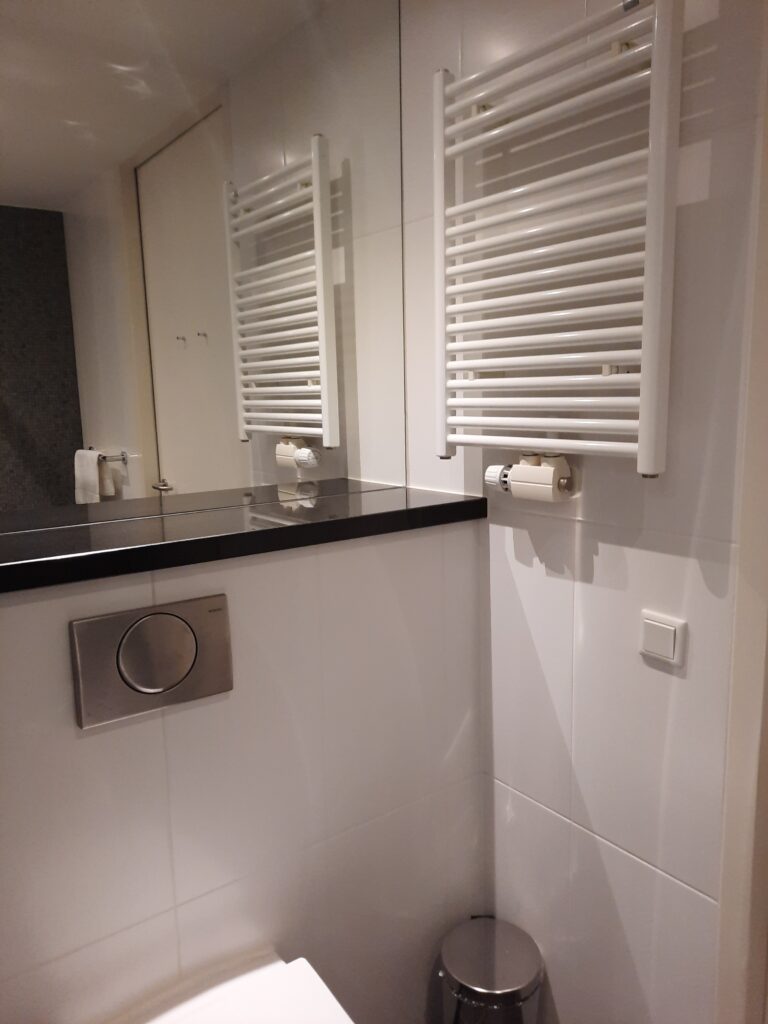 a bathroom with a black counter top and white tile walls