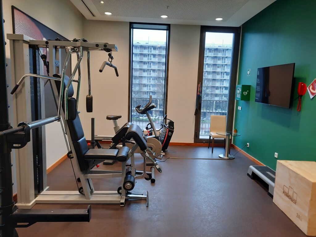 a room with exercise equipment and a television