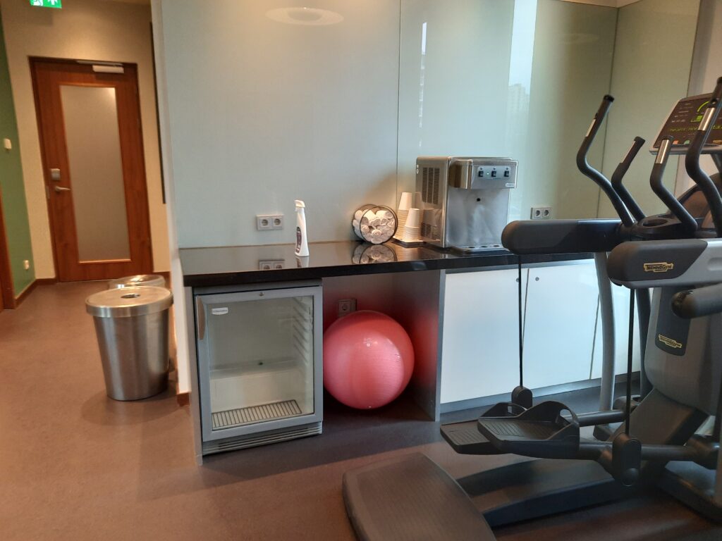 a exercise machine and a refrigerator in a room