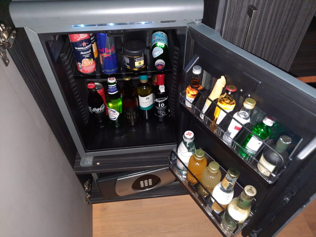 a small refrigerator with bottles of beverages