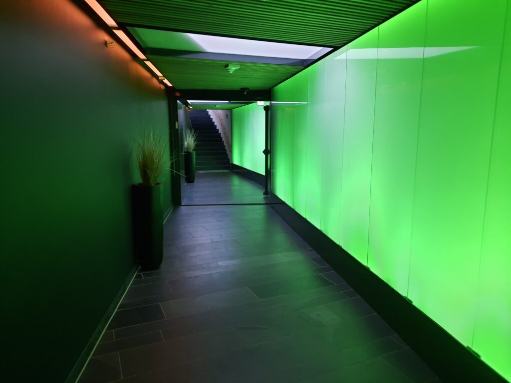 a hallway with green walls and a staircase
