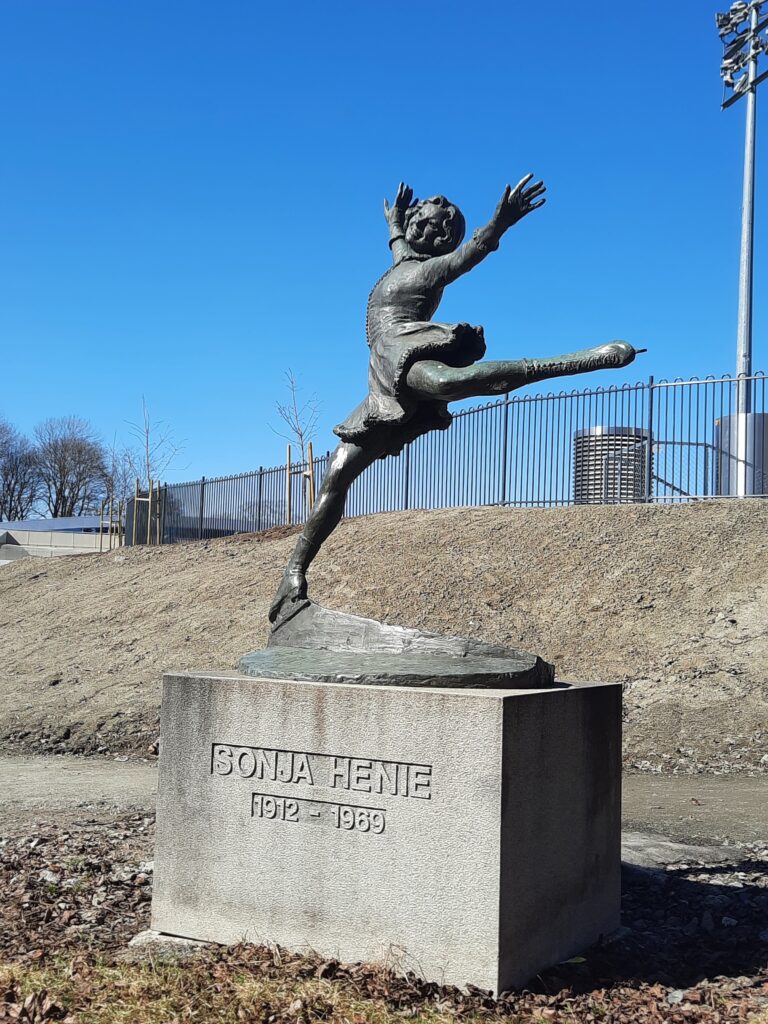 a statue of a girl jumping on a concrete block