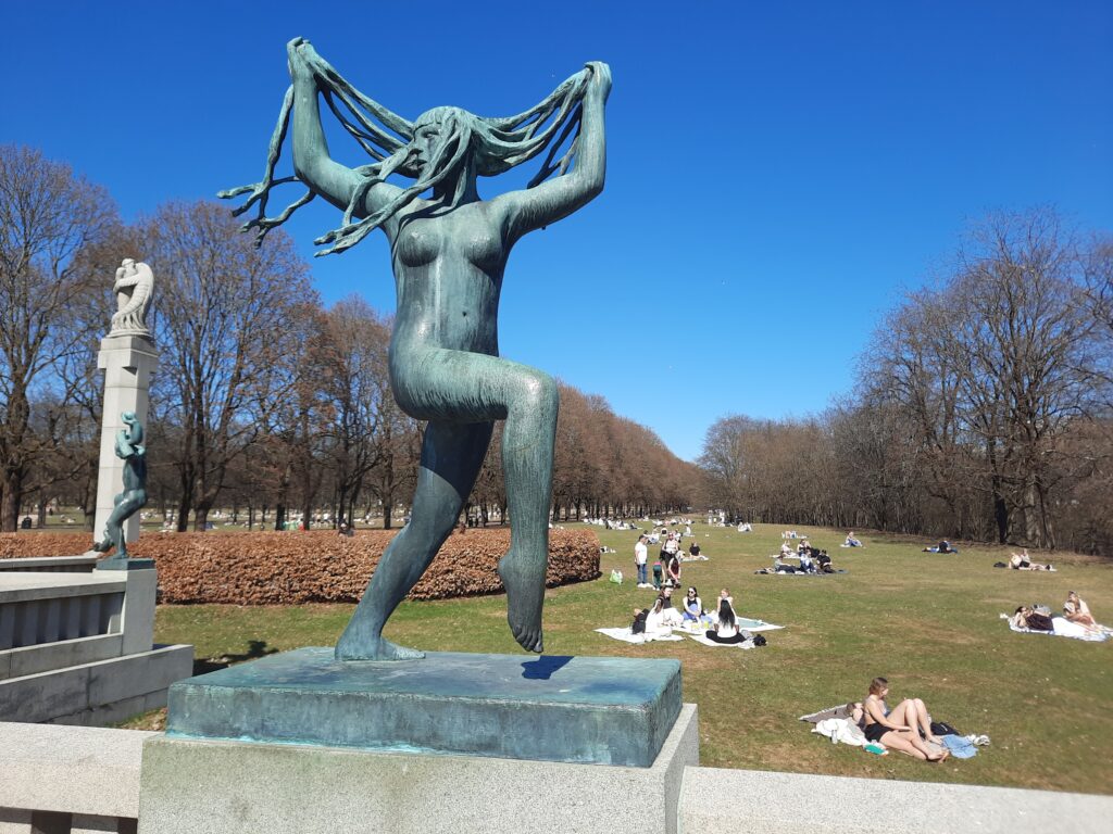 a statue of a woman with long hair in a park