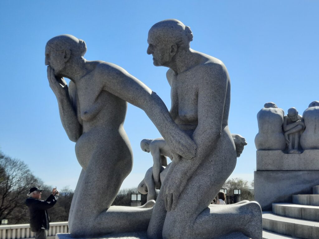 a statue of a man and woman with Bahubali in the background