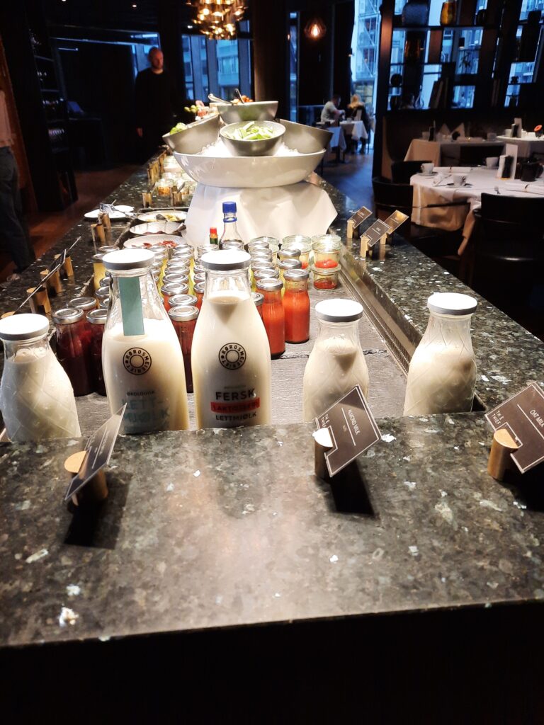 a buffet table with bottles of milk and sauces
