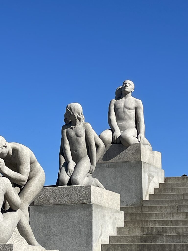 a group of statues of people sitting on steps